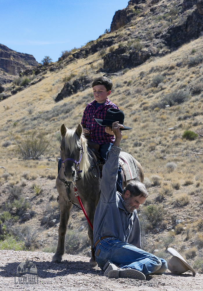 Picture of a bratty kid humiliating a ranch hand during the shooting of the Out of the Wild movie