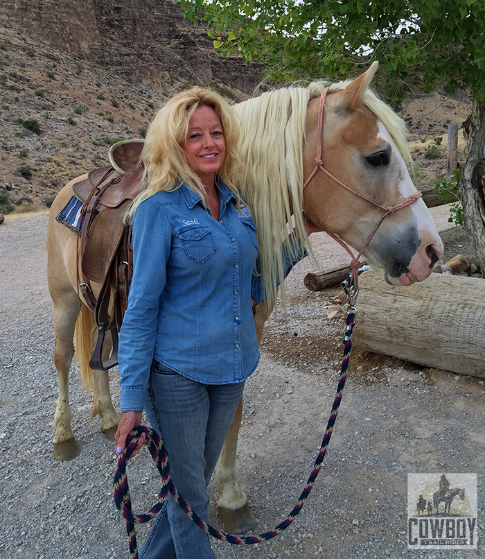 Picture of Wrangler Sandi standing next to a horse whose mane is the same color as Sandi's hair before Horseback Riding in Las Vegas at Cowboy Trail Rides in Red Rock Canyon
