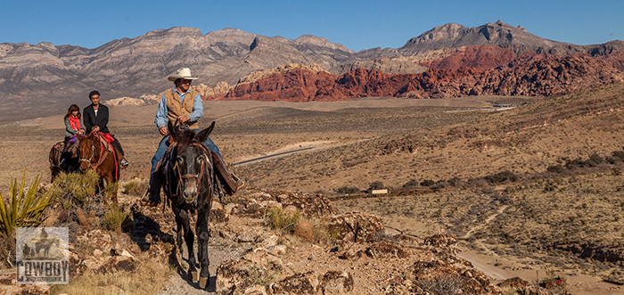Cowboy Trail Rides - Wrangler Robert leads two guests on the Tim Ride with the Calico Hills in the background